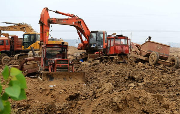 Excavators stand idle at the construction site for a property project in Huaibin, Henan province. Work was suspended after it was reported that the land had been forcibly seized from farmers. Xiang Mingchao / China Daily County halts work on disputed land
