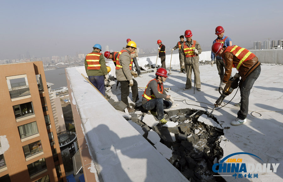 武漢一高層業(yè)主打穿樓頂建“復(fù)式豪宅”被城管拆除