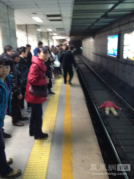 北京一女子地鐵臥軌被強行抱出